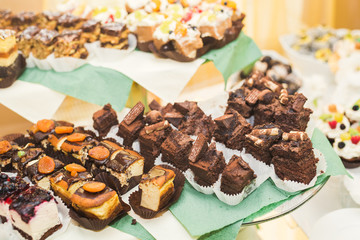 Delicious sweets on wedding candy buffet with desserts, cupcakes