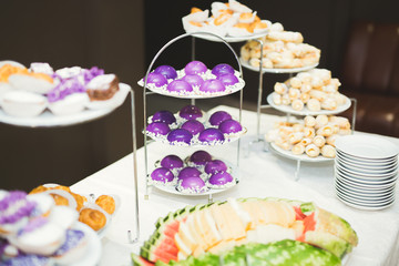Delicious and tasty dessert table with cupcakes shots at reception closeup