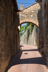 Brick archway and narrow street in San Gimignano, Italy