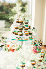 Delicious sweets on wedding candy buffet with desserts, cupcakes