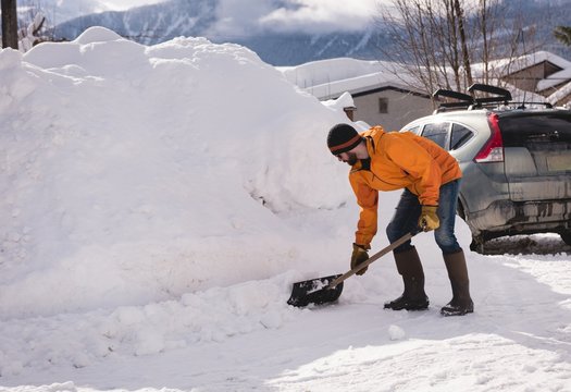 Man cleaning snow with snow shovel