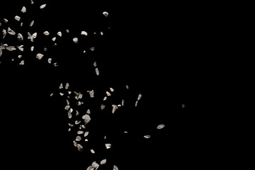 Split debris of stone exploding against black background.