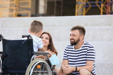 Teenage boy in wheelchair with his family outdoors