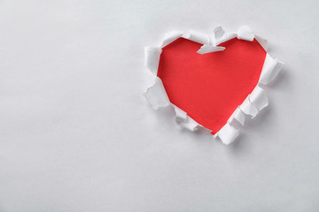 Naklejka na ściany i meble Hole in shape of heart on white paper