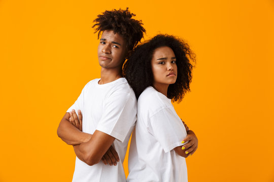 Quarrel young cute african couple isolated over yellow background.