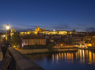 Fototapeta na wymiar Night view from Charles bridge of illuminated St. Vitus Cathedral gothic churche and Prague Castle panorama with hradcany, dark blue sky