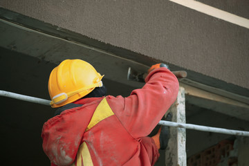 Industrial bricklayer installing bricks on construction site.