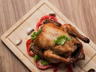 Roasted chicken on wooden board, food concept.