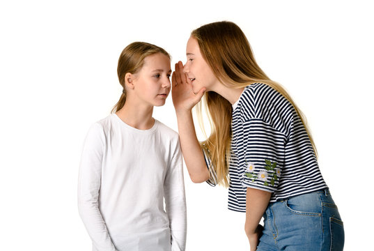 Young teen girls on white background whispering gossips