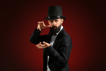 Magician showing tricks on dark background