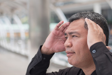 sick old senior man suffers from headahce; portrait of stressed, serious, sick old asian senior man...