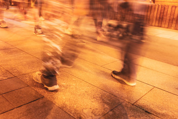 Legs of people in motion on the road as a background