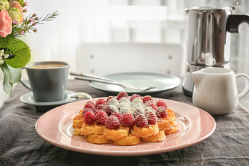 Plate with delicious waffles and berries on table