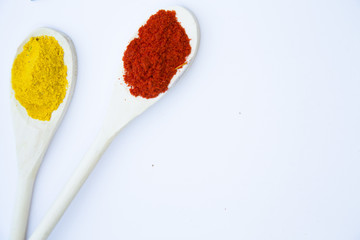 Dry spices and herbs in glass jar with a cork, a bowl of cherry tomatoes and chili peppers, white background