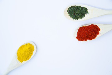 Dry spices and herbs in glass jar with a cork, a bowl of cherry tomatoes and chili peppers, white background