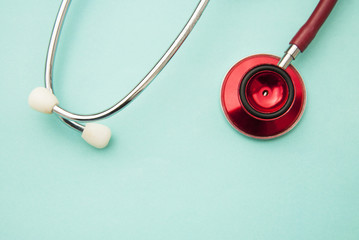 Medical red stethoscope isolated on blue background. Copy space. Healthcare and medicine.