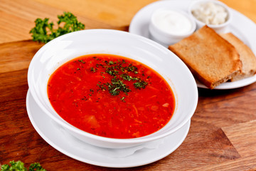 Borscht. Traditional Ukrainian Russian beetroot soup served with sour cream and toasted bread on white plate