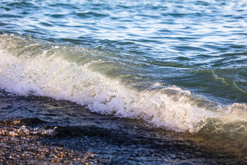 Waves at sea in the rays of sunset