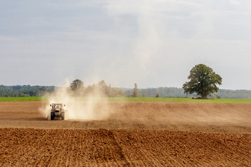Fototapeta premium tractor handles land, very put