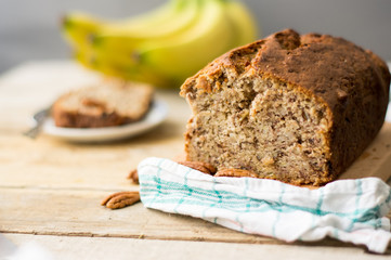 Banana bread loaf with pecans on a wooden table