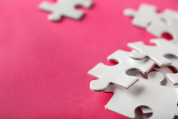 Pieces of jigsaw puzzle on color background, closeup