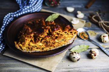 baked meat pie with macaroni and cheese filling on a plate