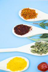 Cooking Hot Spicy Food Concept. Dry spices and herbs in wooden spoons, light blue background