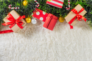 Christmas gift boxes and decorative ornaments on white wool, top view