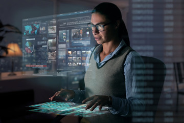Close up of a beautiful girl with glasses while she is working with a futuristic computer with holograms. Concept: Future, technology, work