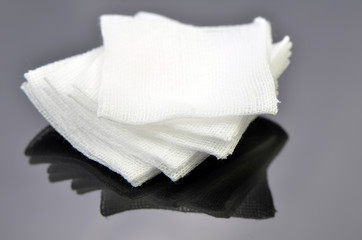 Stack of sterile gauze pad on dark background.