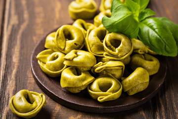 Homemade Tortellini with spinach, cheese and ricotta on wooden board. Gluten free italian food concept.