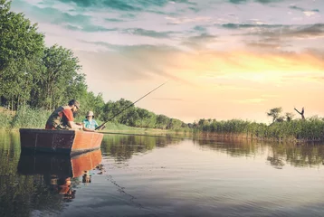 Fotobehang Vader en zoon vissen vanaf een boot © Cherries