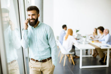 Young businessman using mobile phone in office