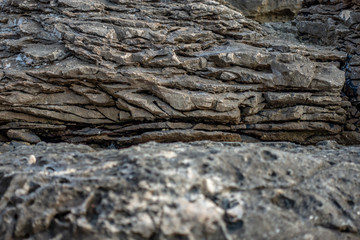 Stone texture background. Real stone on the cliff by the sea.