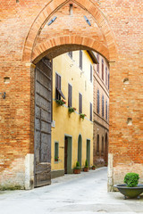 Street through a city gate to an old Italian village