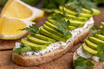 Avocado toasts and ingredients on gray slate background