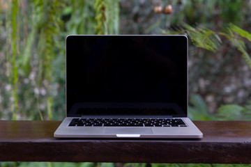 Laptop with blank screen on table. Conceptual workspace, Laptop computer with blank white screen on table, Blurred background.