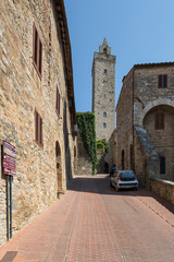 Fototapeta na wymiar Steep road leading up to a smaller tower in the beautiful hilltop town of San Gimignano, Italy