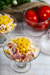 Delicious salad of crab sticks, cheese, tomato and corn.