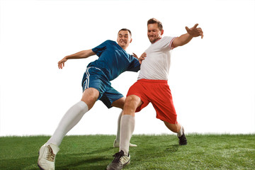 Football players tackling for the ball over white background. Professional football soccer players in motion isolated white studio background. Fit jumping men in action, jump, movement at game. © master1305