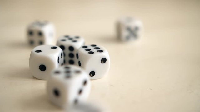 Dice landing on table in slow motion.