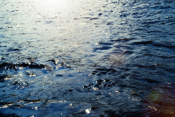 Water surface with ripples and sunlight reflections