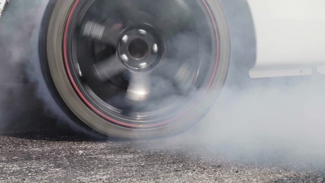 Drag racing car burns rubber off its tires in preparation for the race