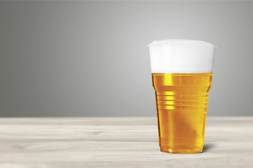 Plastic glass with beer on table