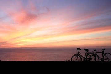 Fototapeta na wymiar Silhouette of bicycle on the beautiful sunset sky background,Ride the bike on orange sky scene. Abstract Silhouette and Sport Concept.
