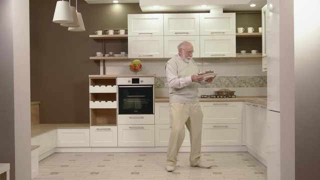 Cheerful Old Man Dancing In The Kitchen