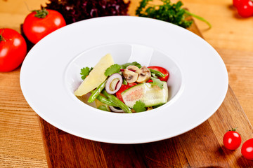 Vegetable salad with parmesan cheese on white plate. Close up