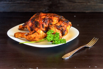 baked chicken on a dark wooden background.