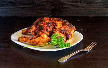 baked chicken on a dark wooden background.