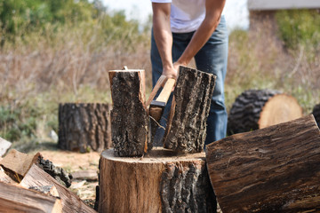 Lumberjack chopping wood for winter, Young man chopping woods with an axe